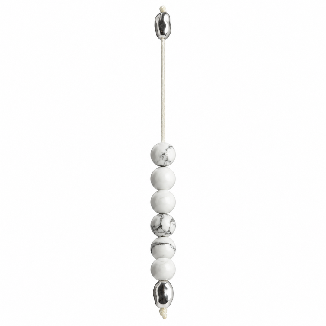 A minimalist beaded hanging cord ornament featuring alternating matte white and polished metallic silver beads on a thin white cord, shown against a solid white background.