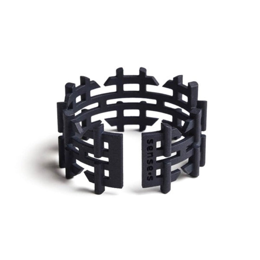 A black 3D printed handcuff bracelet with a geometric pattern.