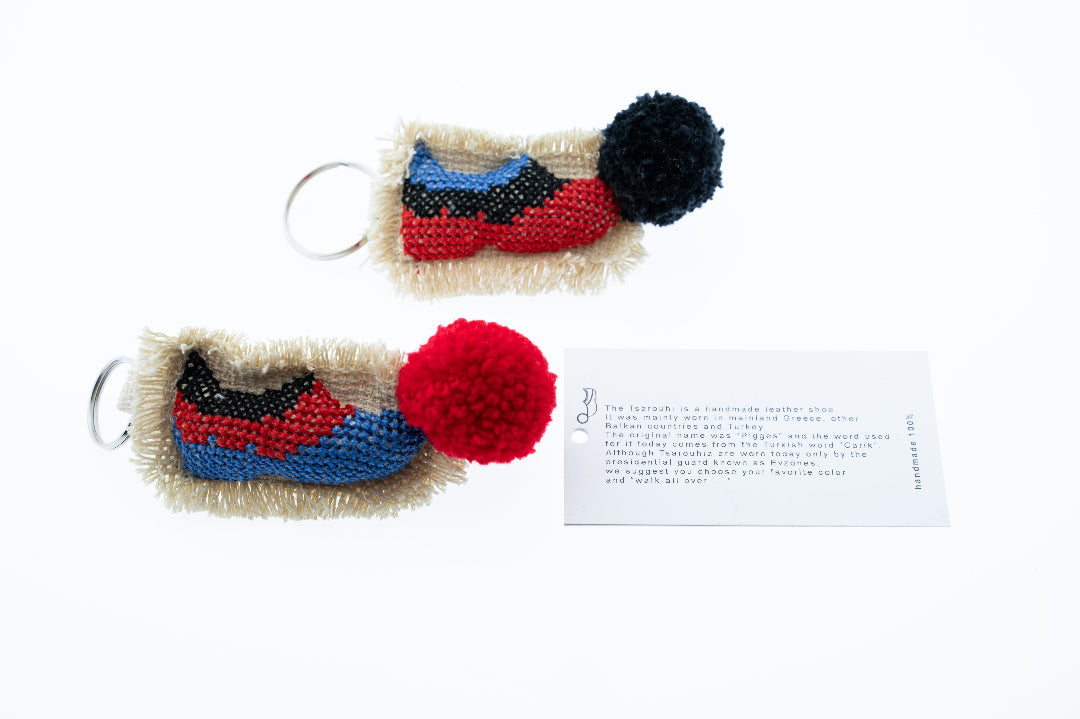 Two colorful keychains with pom-poms on a white background