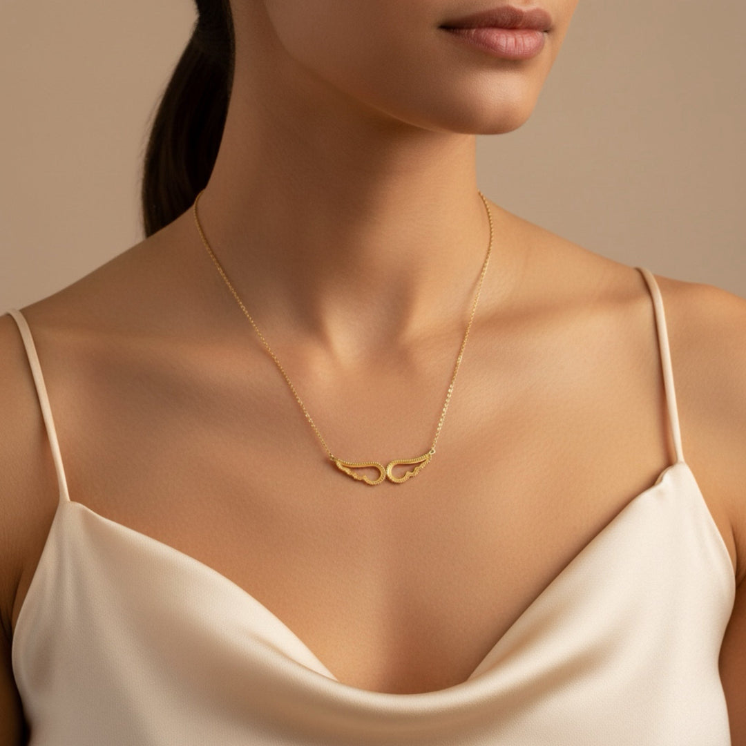 Gold necklace worn by a model against a neutral background
