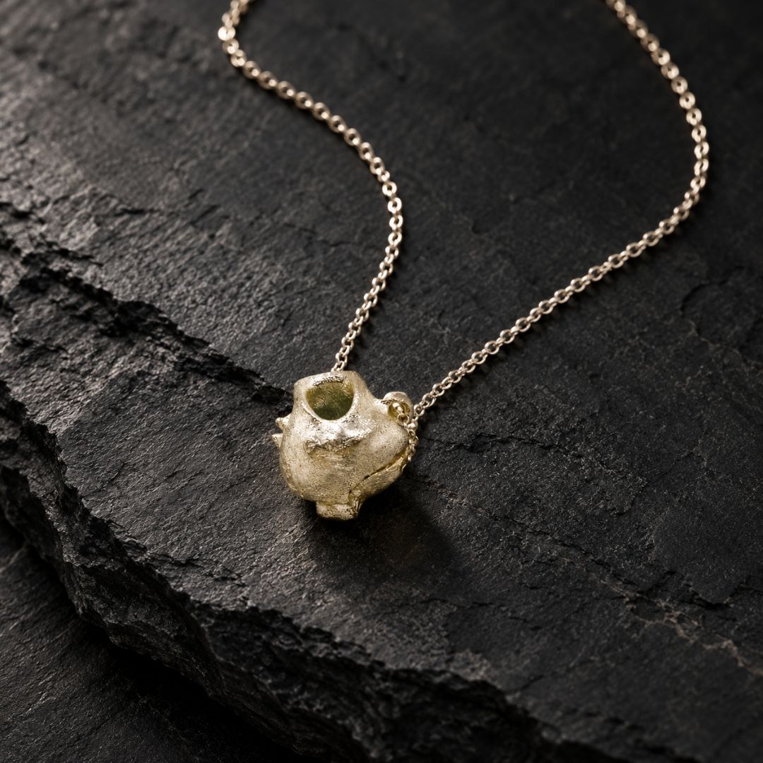 Gold pendant necklace on slate