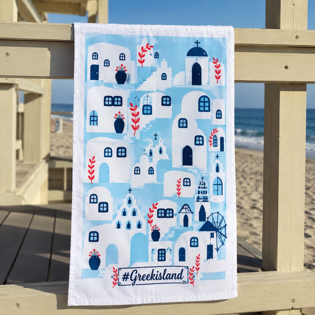 Greek Island Cotton Tea Towel – screen-printed Greek island village design in aqua and white, styled beach view | Thalassea