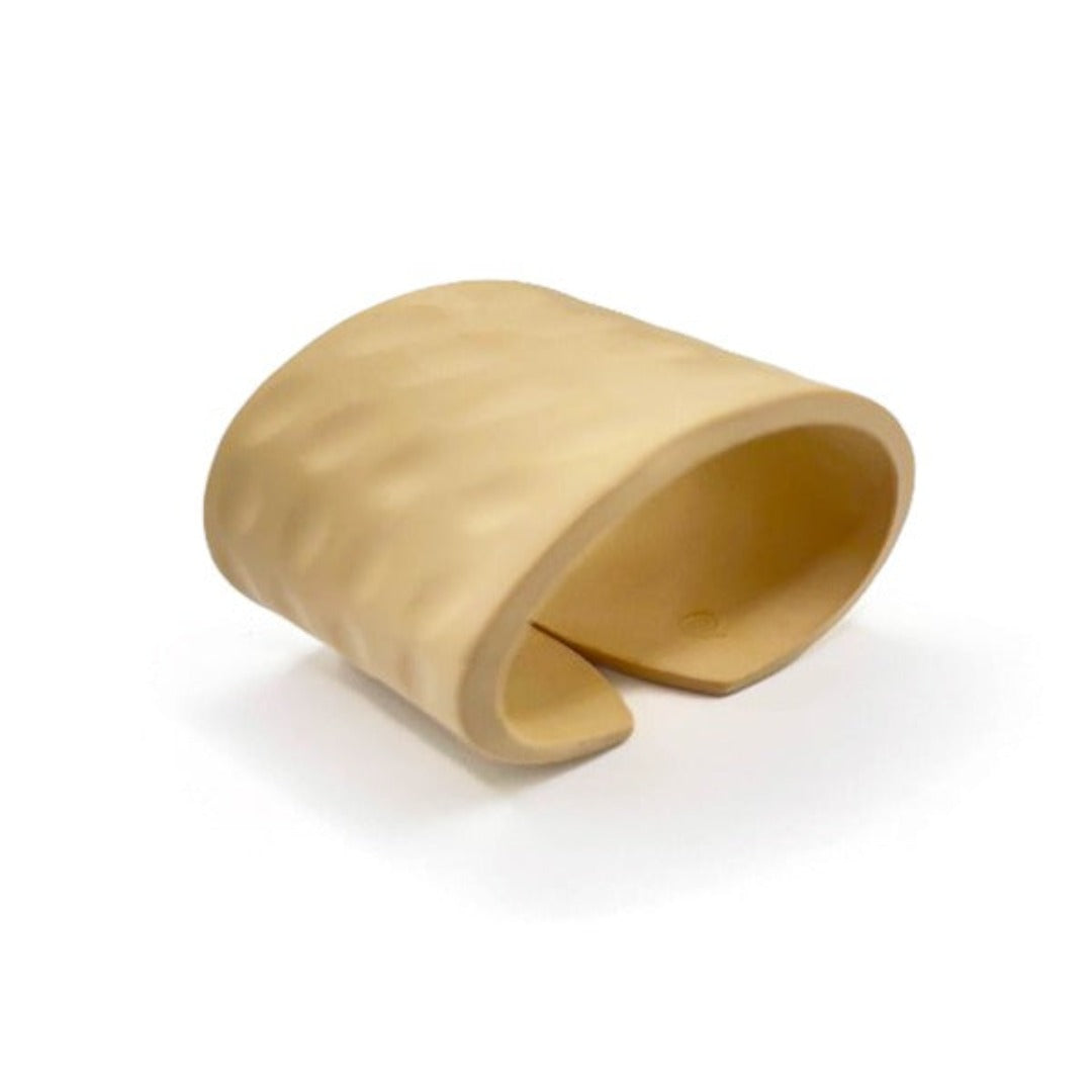 A beige Amani handmade bracelet made of polymeric clay, displayed against a white background.