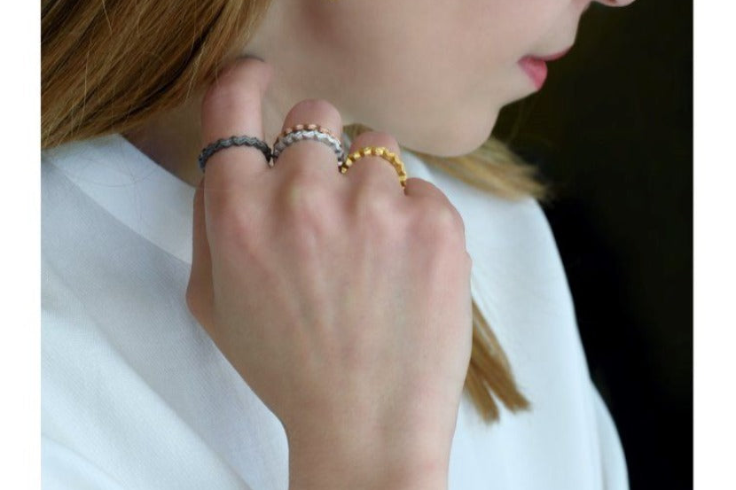 Close-up of a person wearing multiple rings on their fingers.