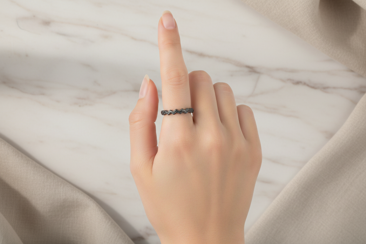 Hand wearing a ring on a neutral fabric background