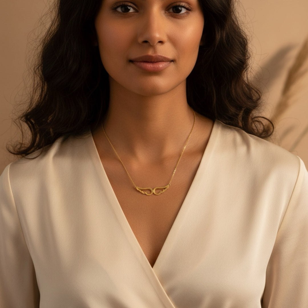 Woman wearing a gold necklace with a beige background