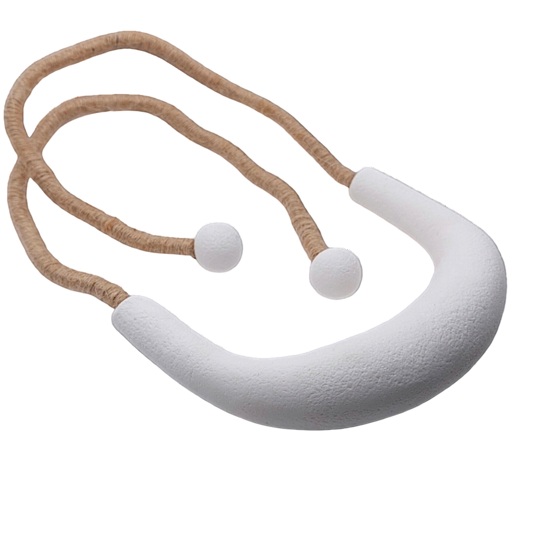 White baby teething ring with a brown rope on a white background