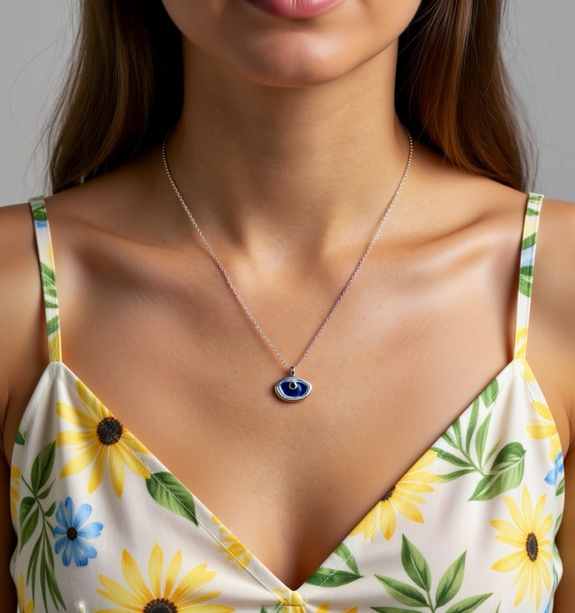 Woman wearing a floral dress and a necklace with an eye pendant.