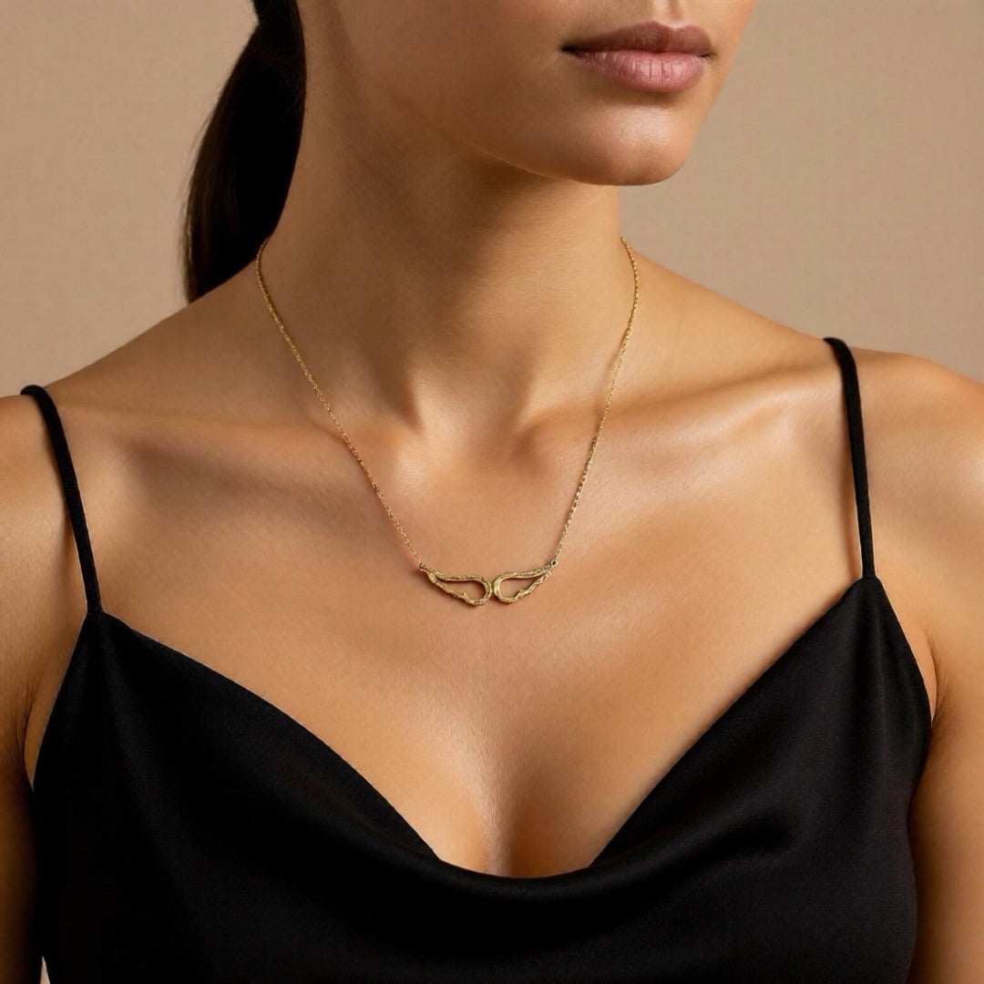 Woman wearing a gold necklace with a beige background