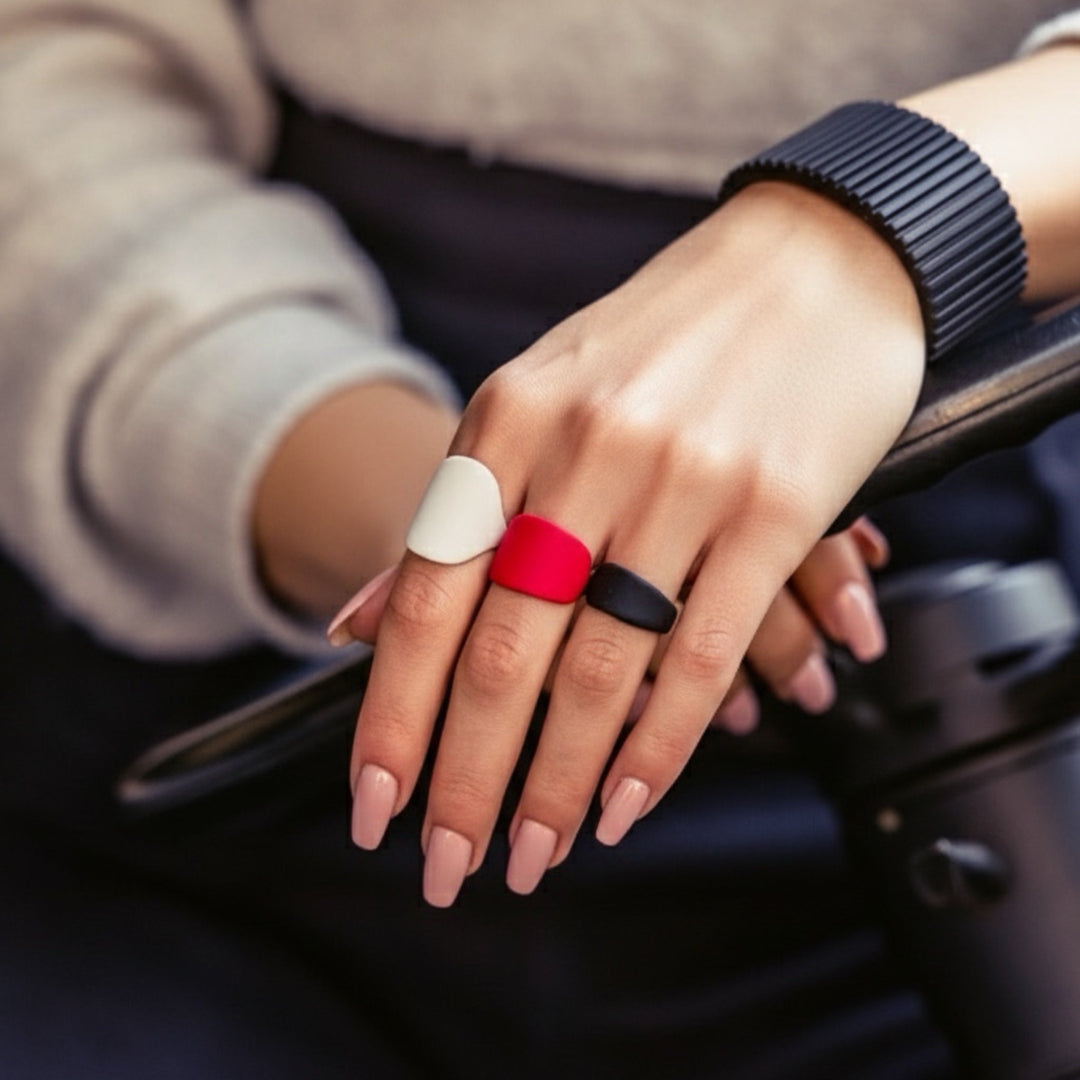 Close-up of a hand wearing three rings with a blurred background
