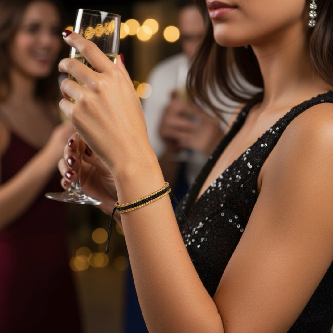 Woman in a black dress holding a glass of champagne with blurred background