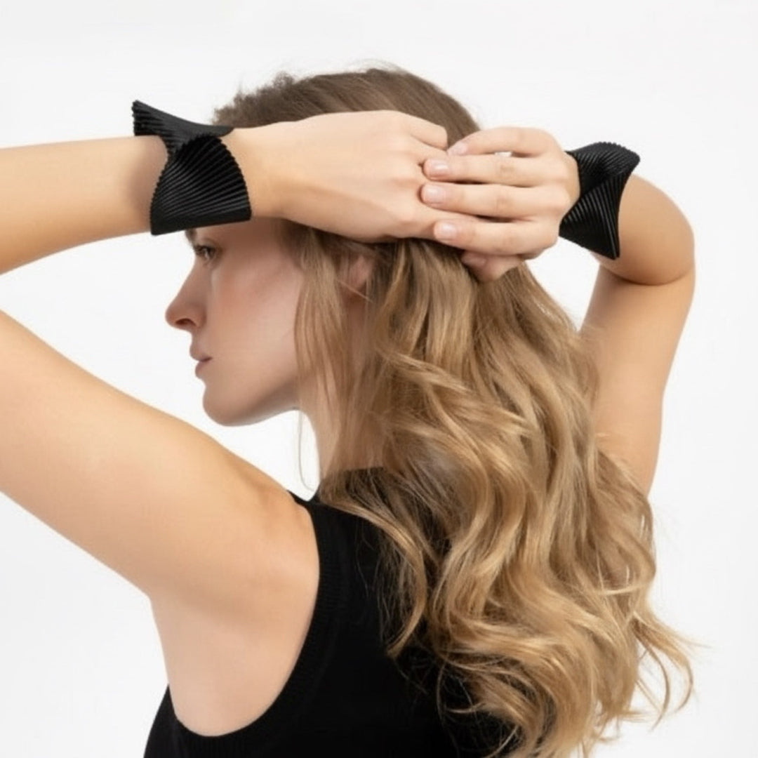 Woman with long blonde hair using black hair extensions on a white background