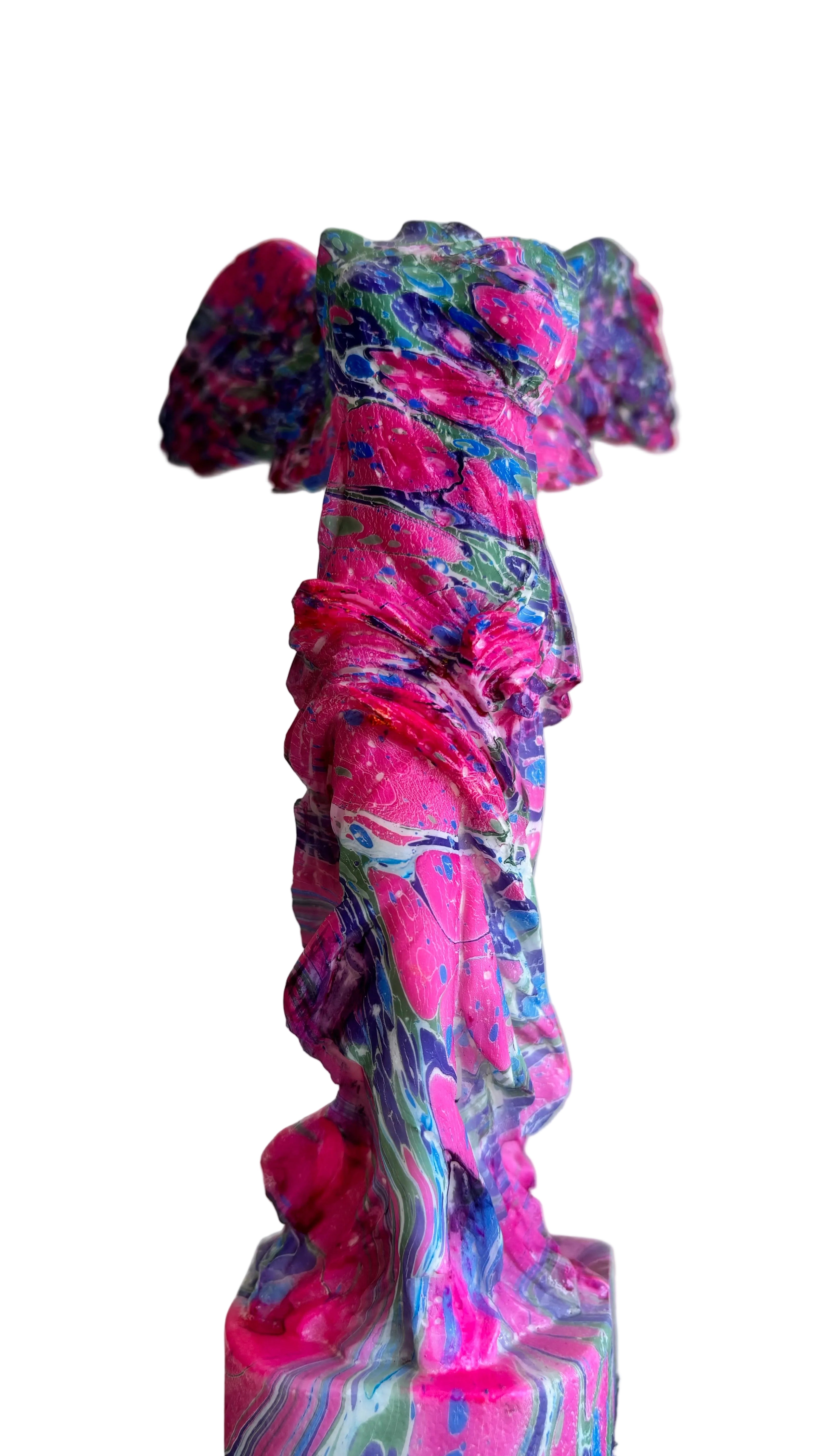 Colorful abstract sculpture on a white surface with a light gray background