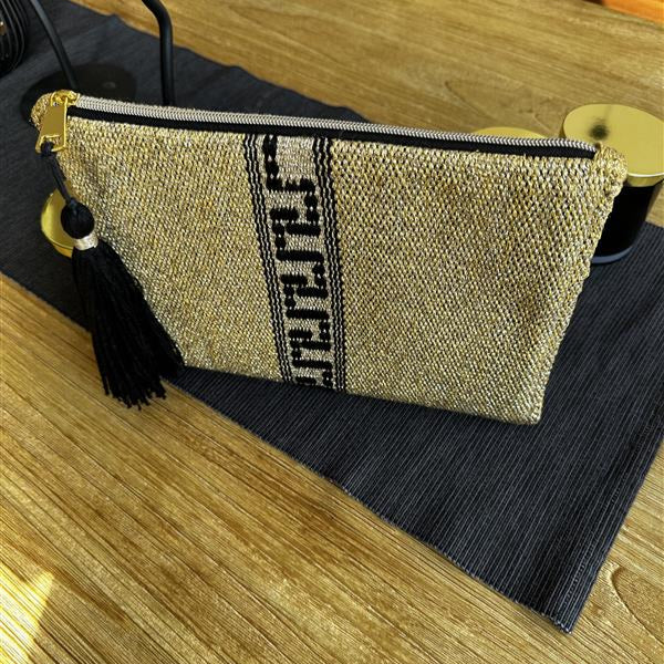 Textile pouch with tassel on a wooden surface