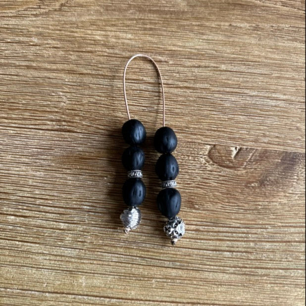 Black beaded earring on a wooden surface