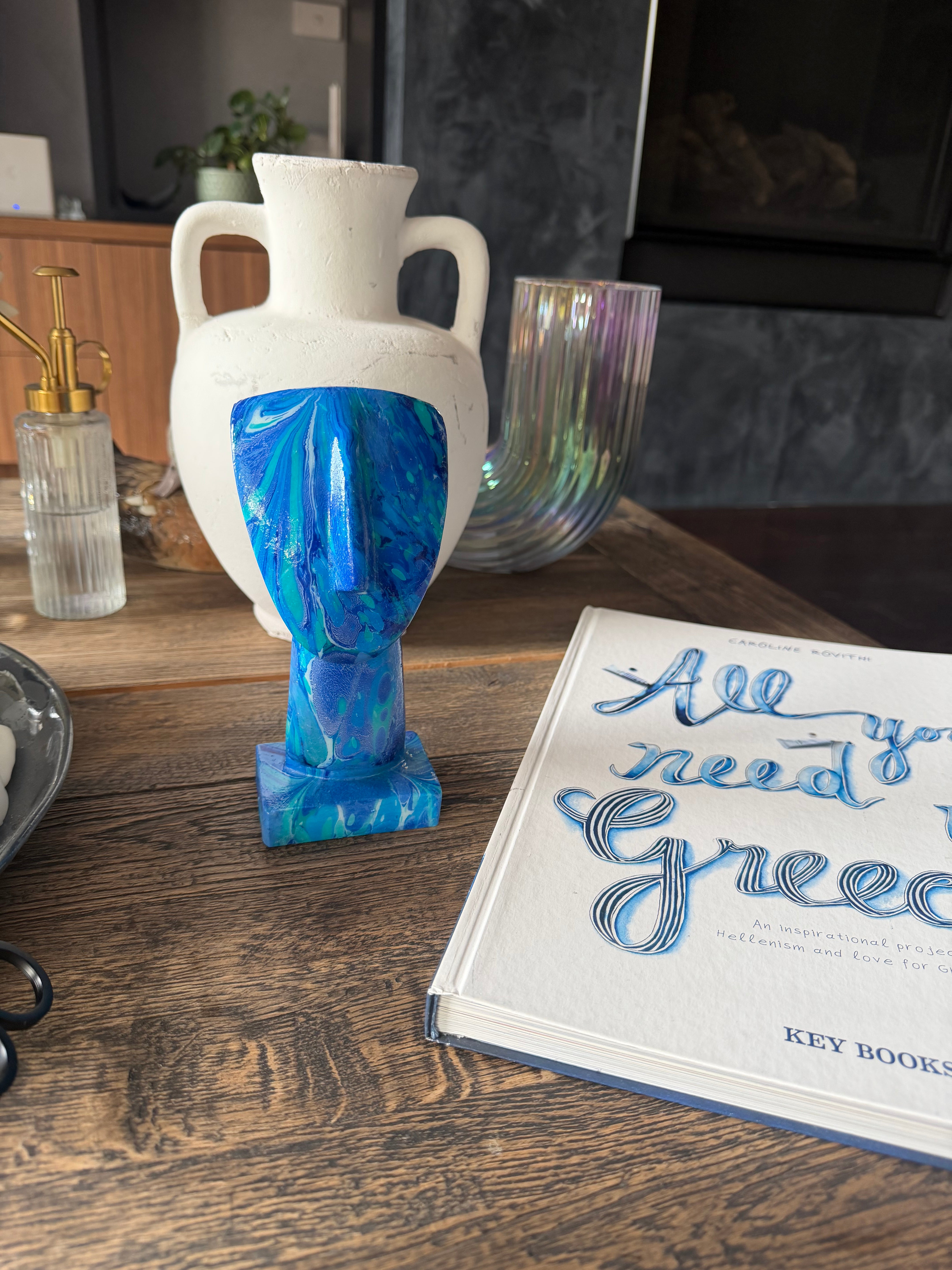 Decorative blue and white vase on a wooden surface with a book in the background