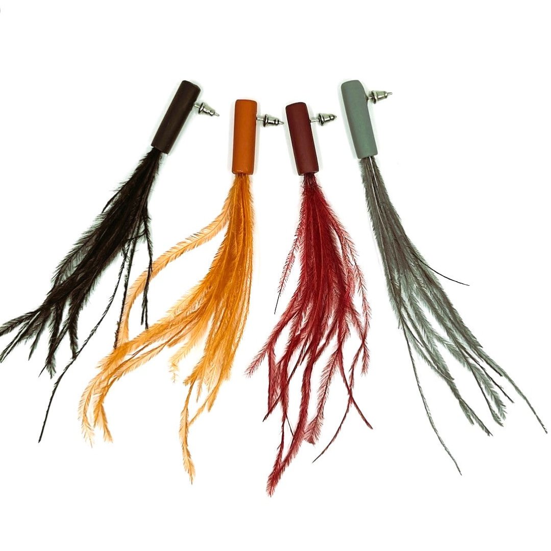 A collection of Obi earrings in various colors, featuring polymeric clay and feather accents.
