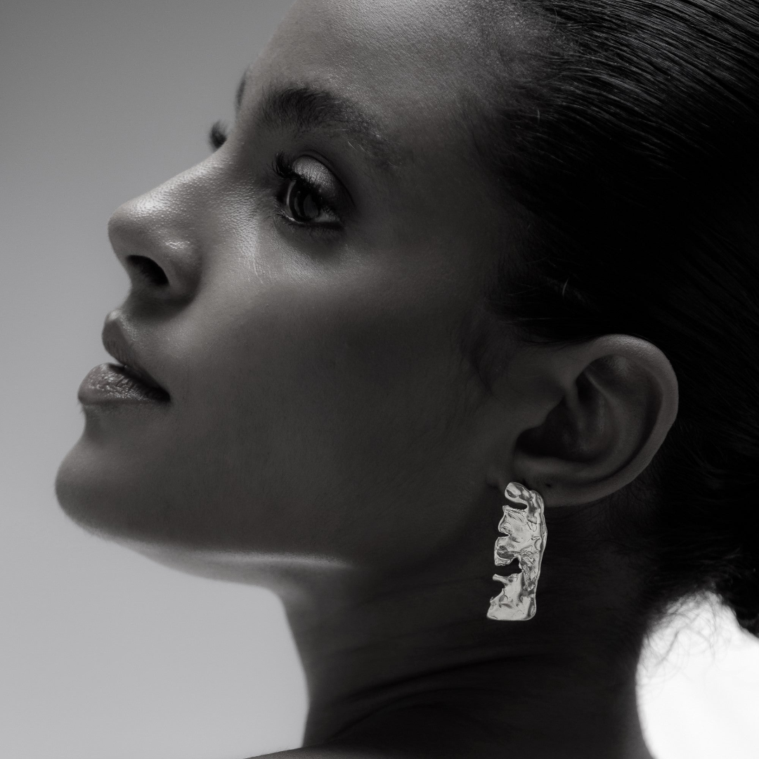 Black and white portrait of a woman wearing earrings with a blurred background