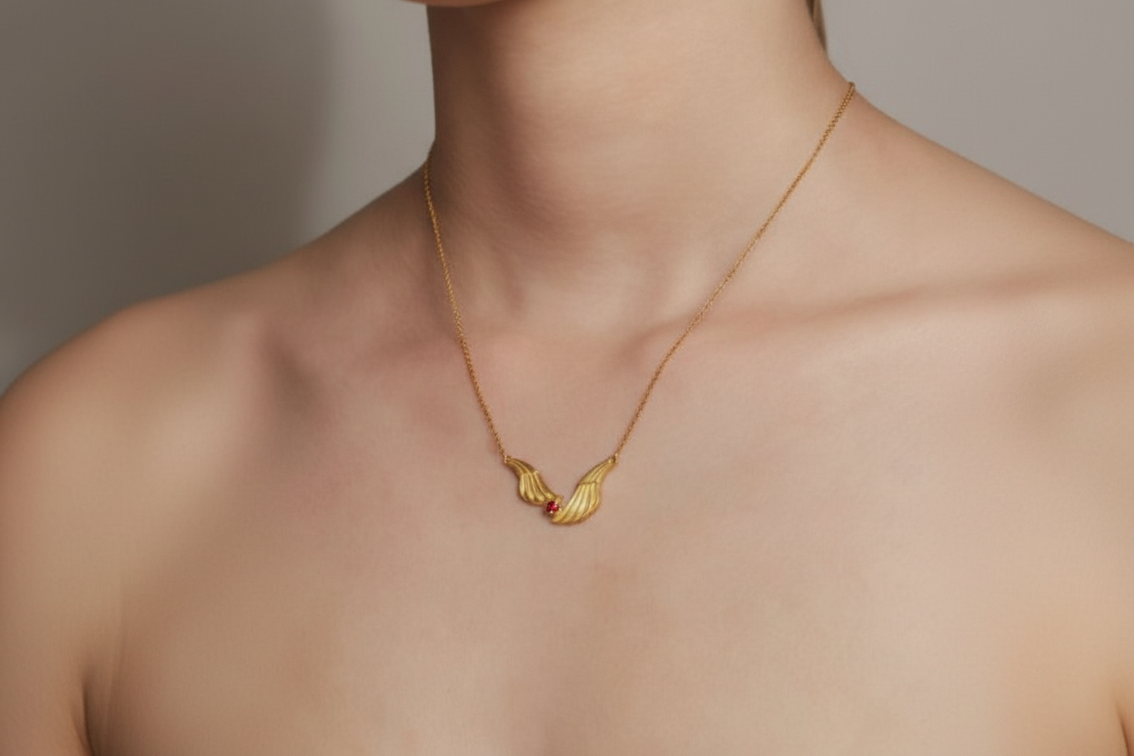 Gold necklace with a delicate pendant on a neutral background