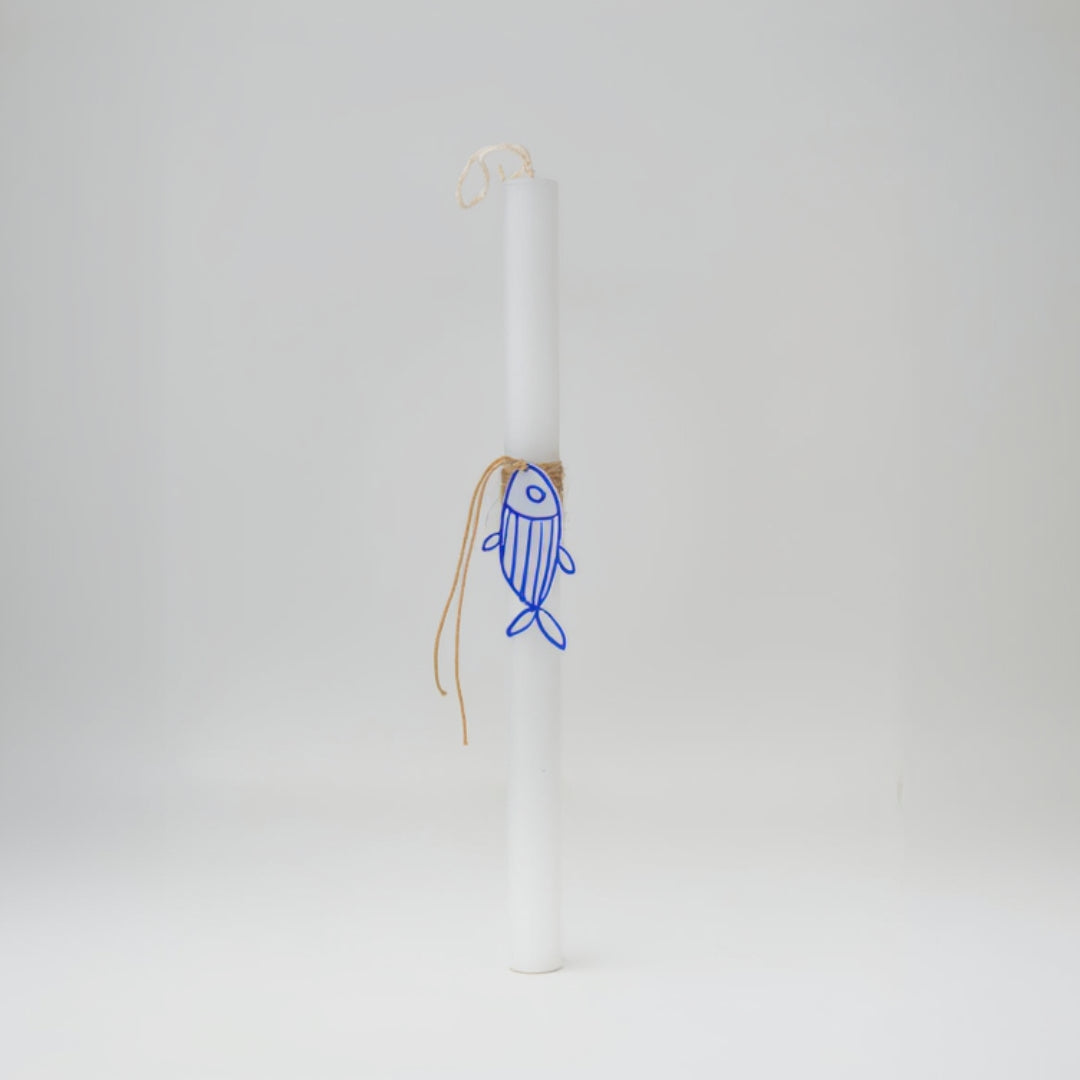 White candle with a blue fish design on a white background