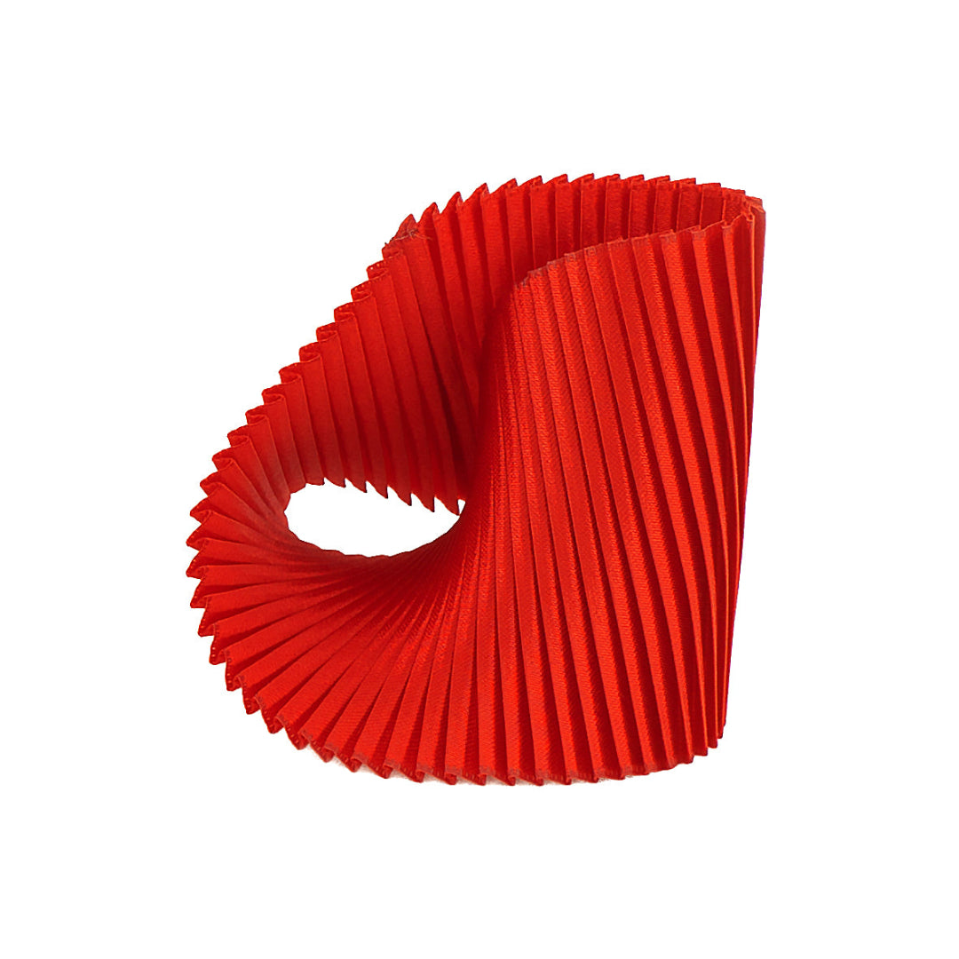 Red pleated paper cupcake liner on a white background