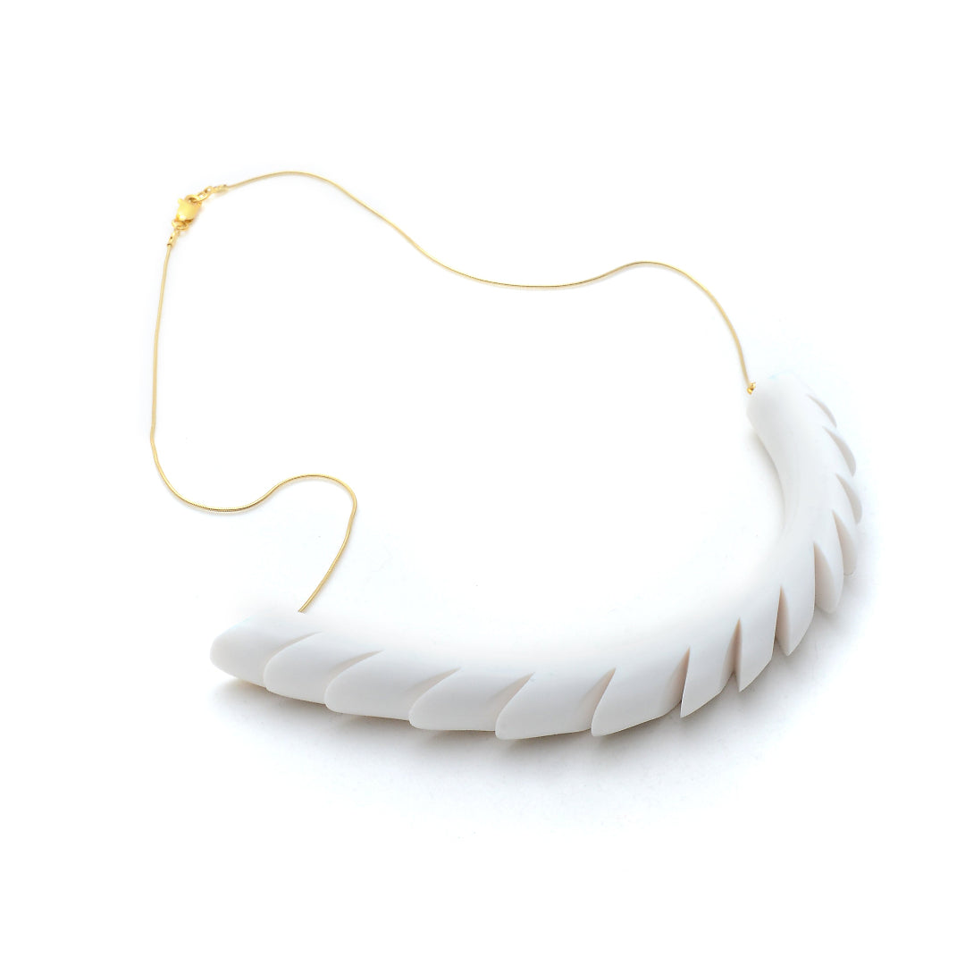 White feather-shaped necklace on a white background