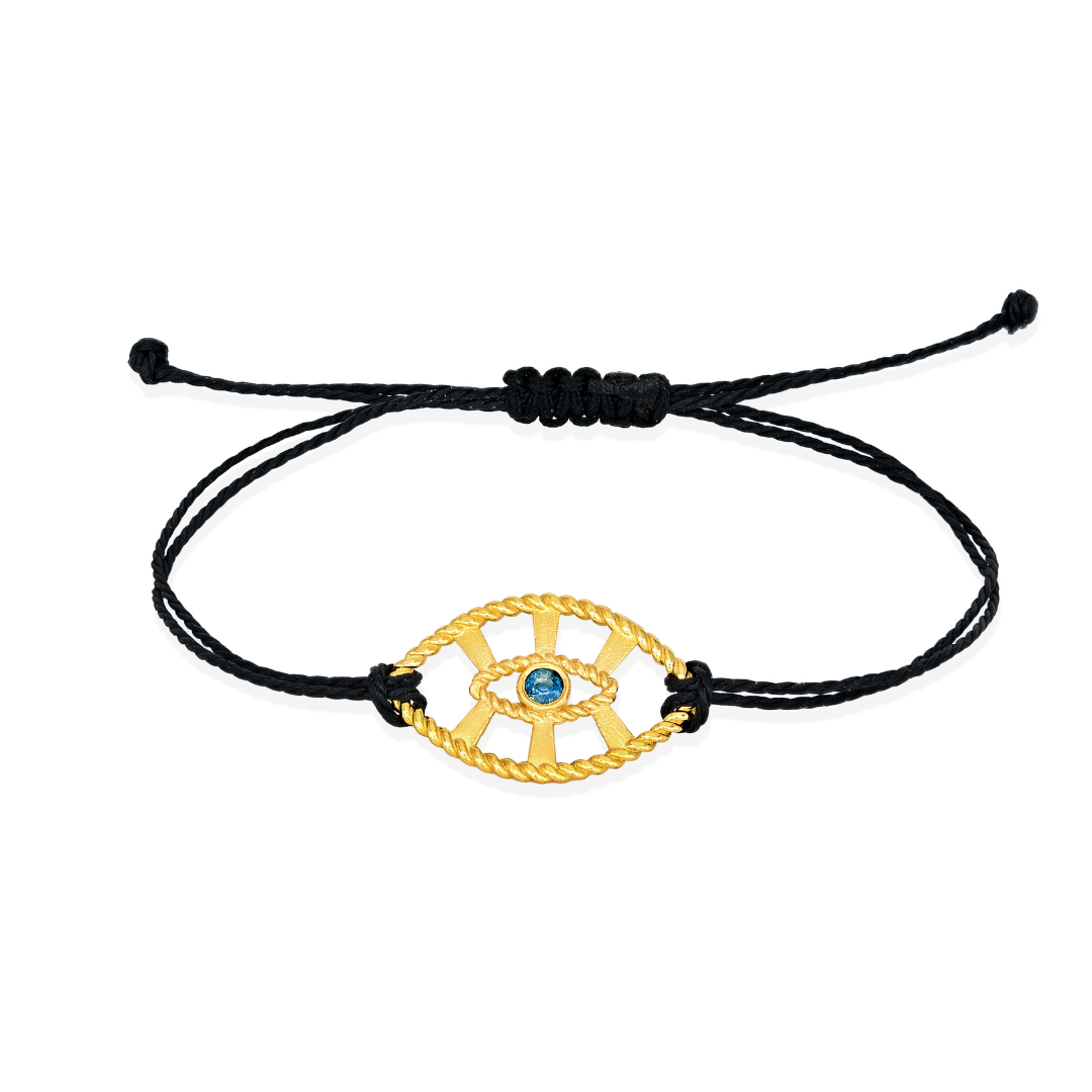 Black cord bracelet with a gold eye-shaped charm on a white background