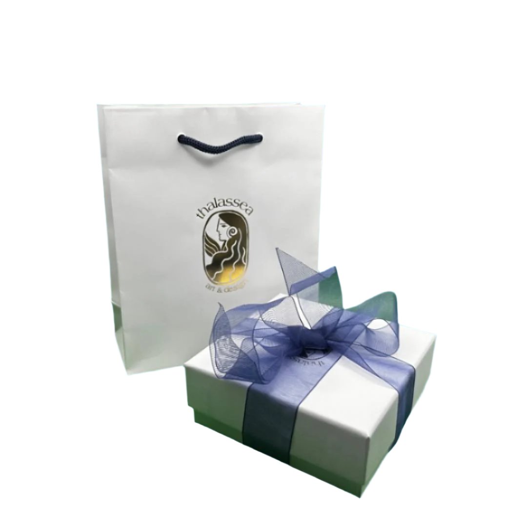 A white gift bag with a blue ribbon on top, next to a silver gift box with a blue ribbon tied around it, against a white background.