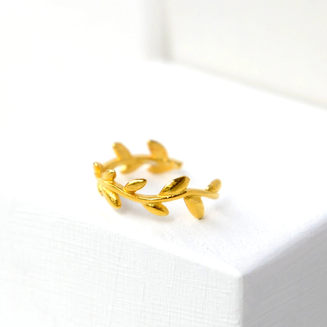 Gold leaf-shaped earring on a white background