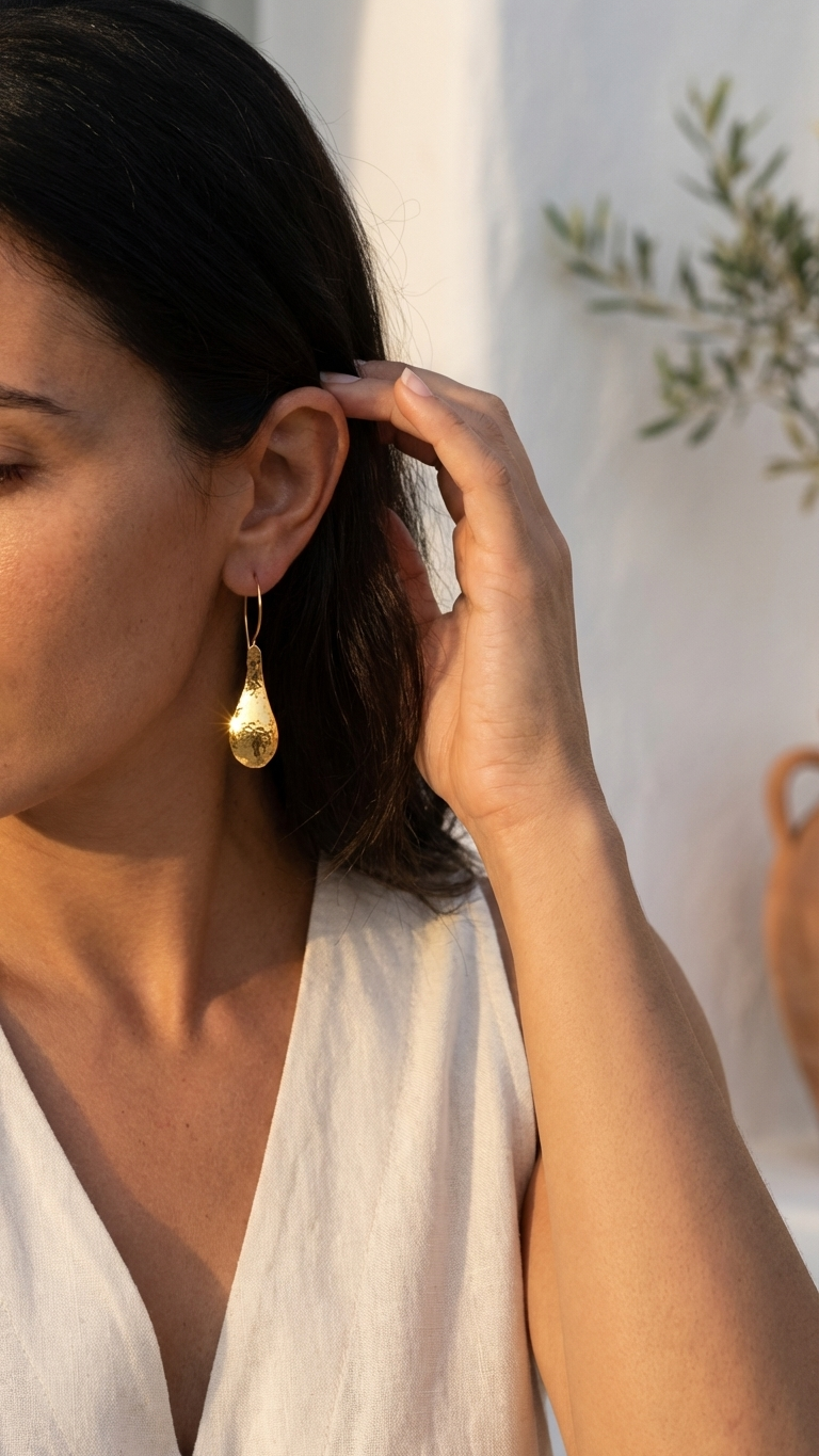 Woman wearing a gold earring with a white background