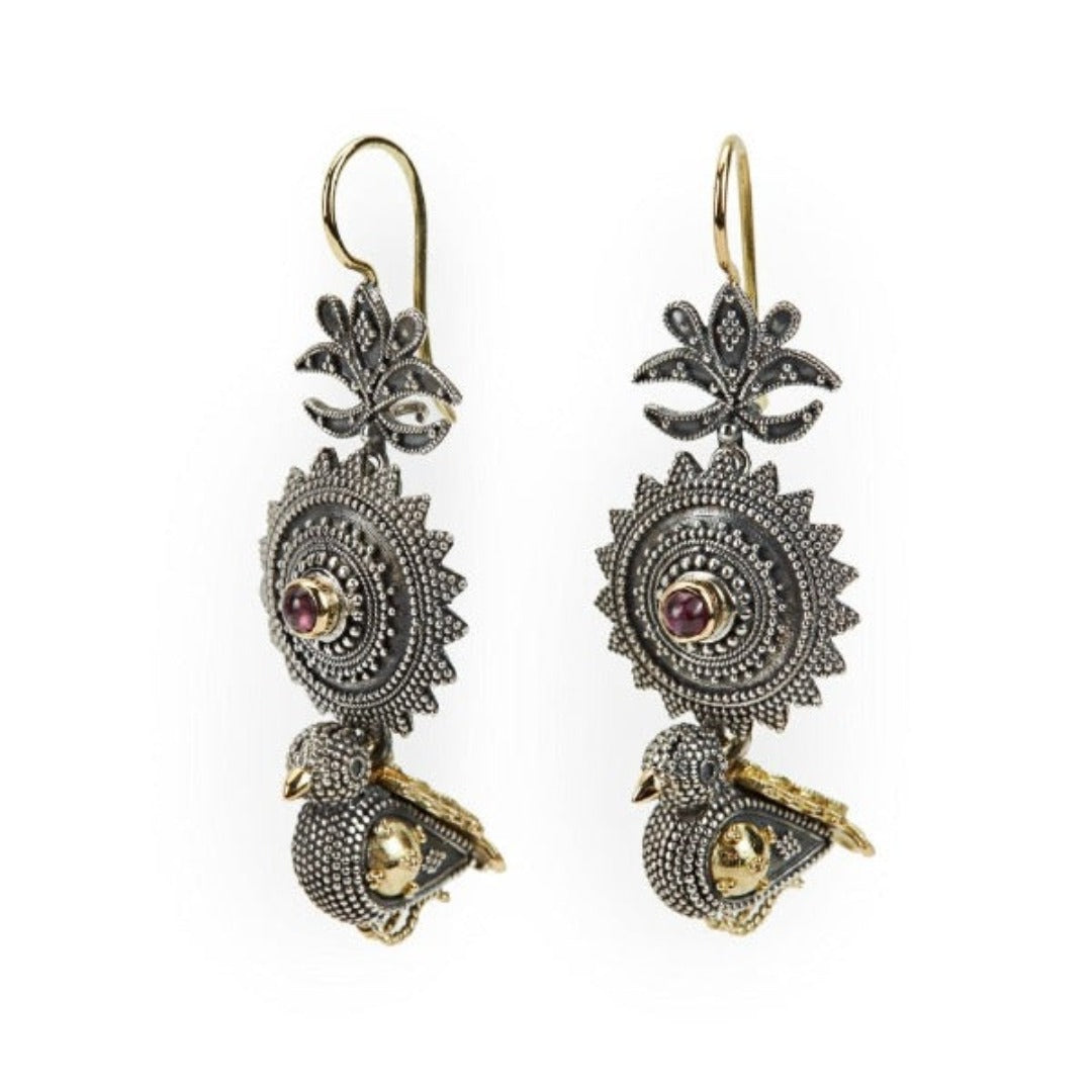 A pair of silver and gold earrings featuring intricate designs and small ruby stones, with a length of 4 cm.