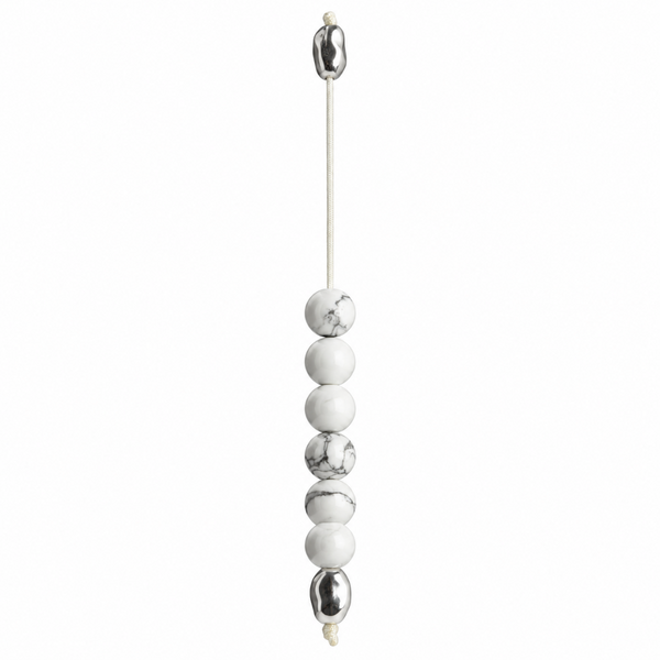 A minimalist beaded hanging cord ornament featuring alternating matte white and polished metallic silver beads on a thin white cord, shown against a solid white background.