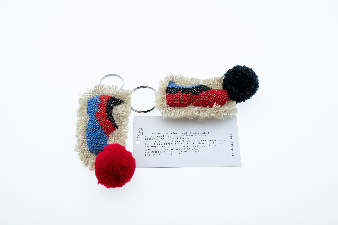 Two colorful keychains with pom-poms on a white background