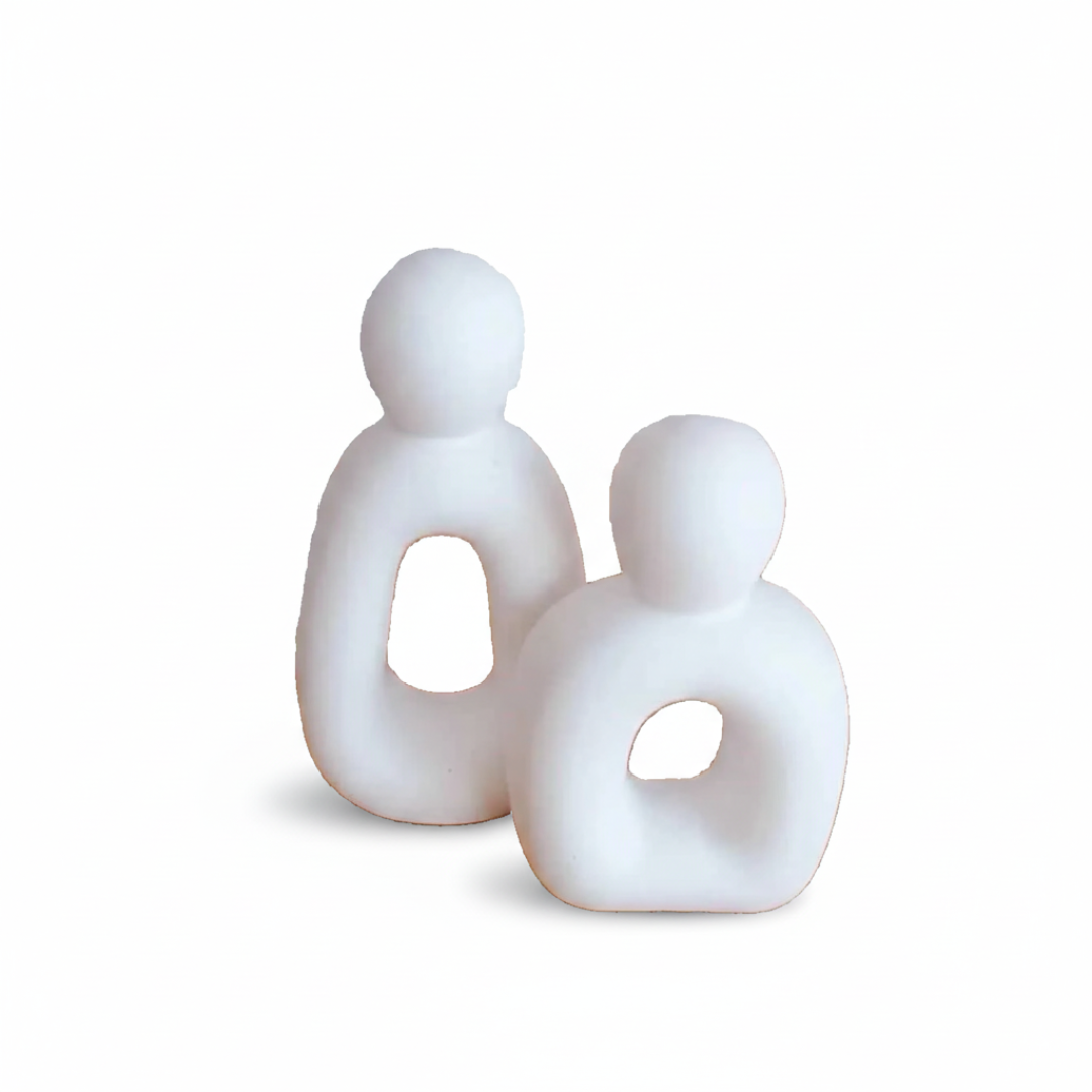White abstract sculpture of two figures on a white background