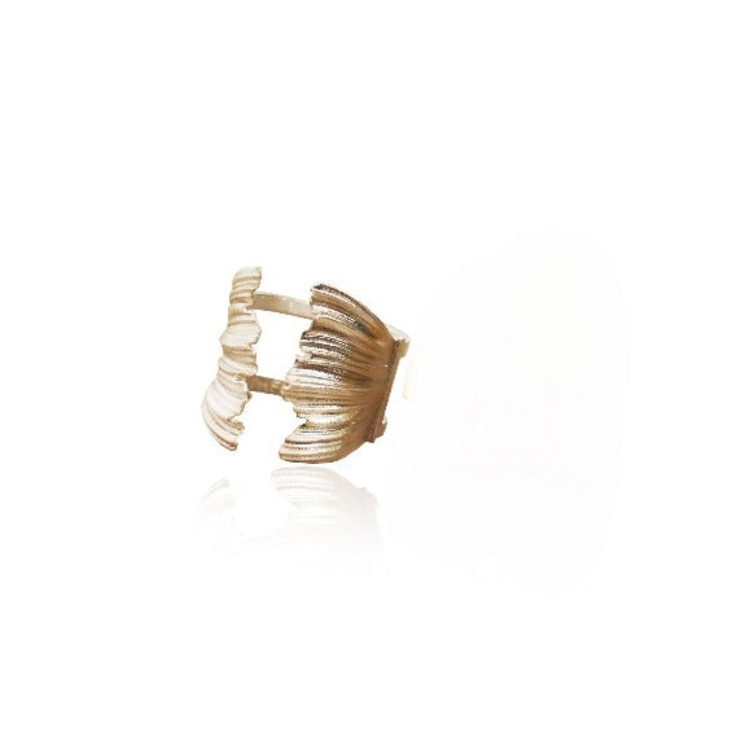 Gold ring with a textured design on a white background