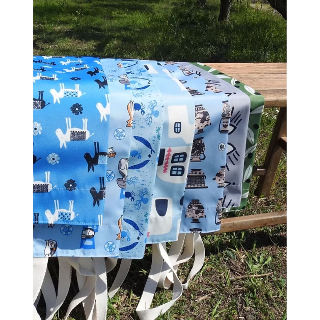 A Hue of Greek Blue water-resistant aprons in assorted Greek designs, styled | Thalassea