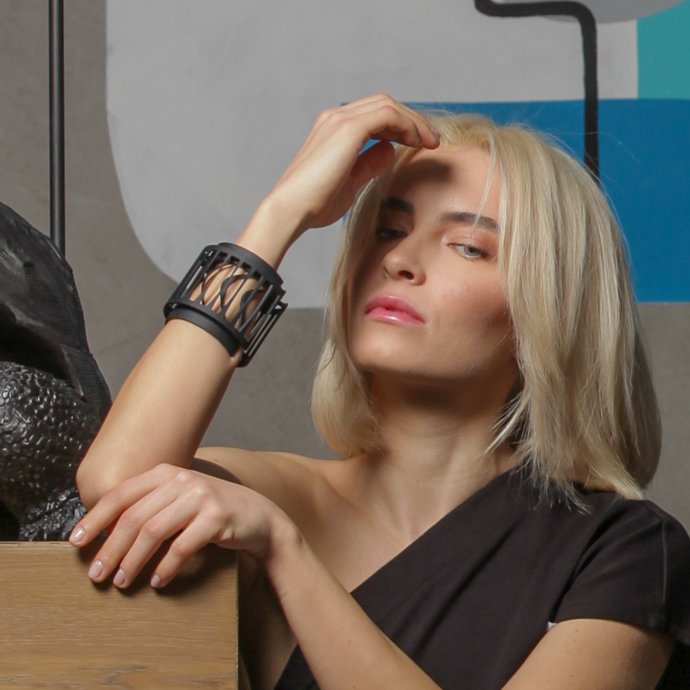 Woman wearing a black bracelet with a modern interior background
