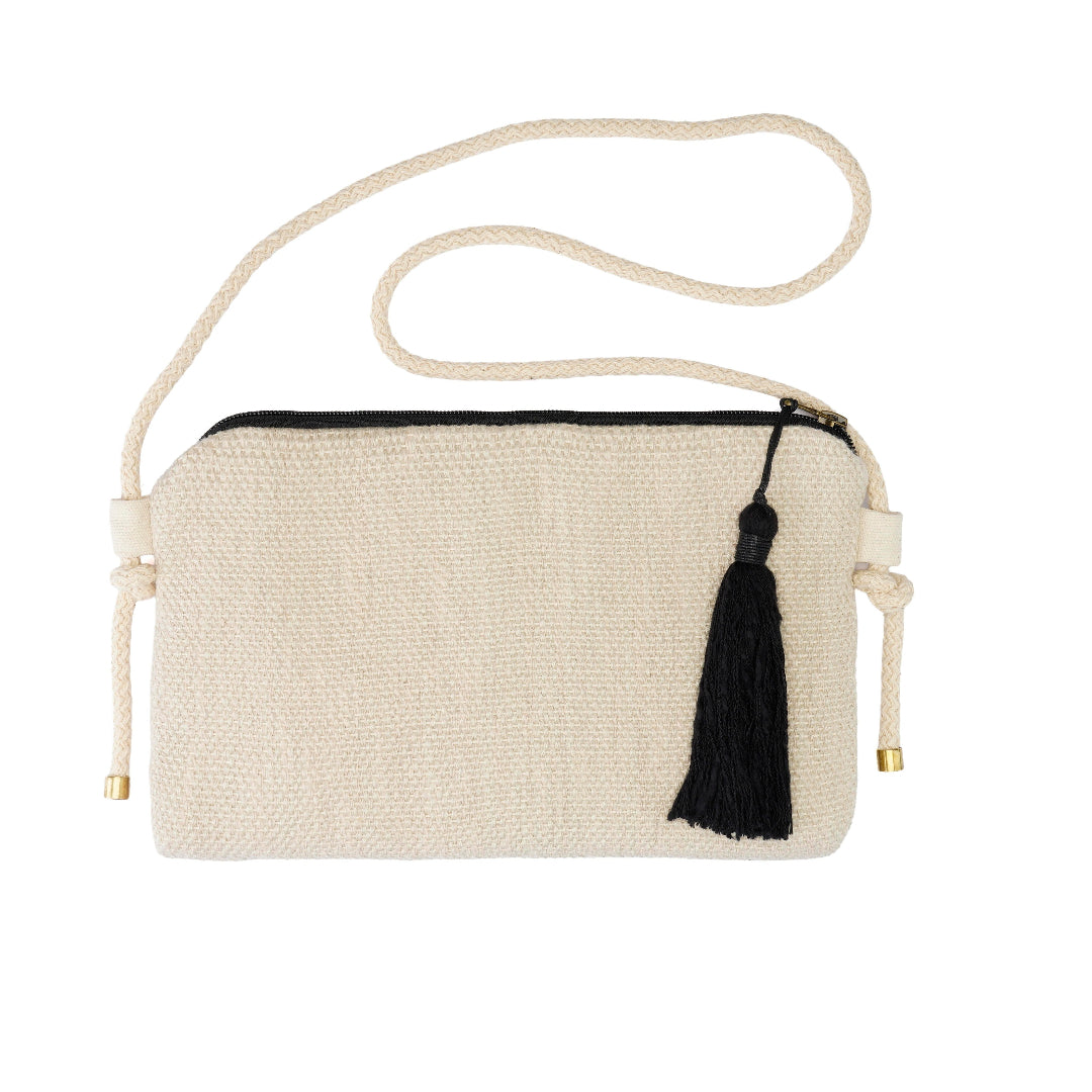 A cream-colored woven crossbody bag with a black zipper, a black tassel charm, and a thick cream rope strap with gold-toned hardware, shown on a plain white background.