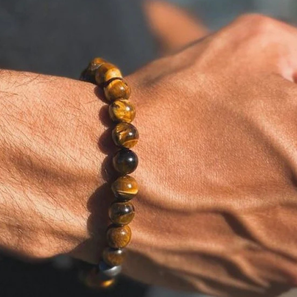Hand wearing a beaded bracelet on a blurred background
