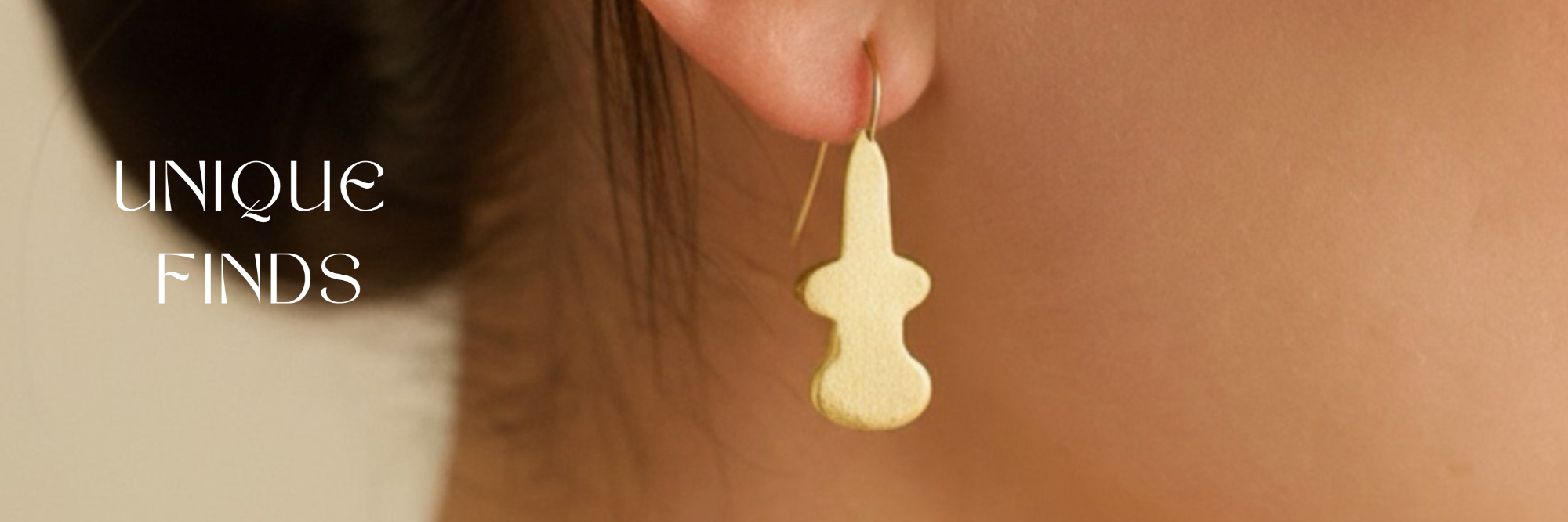 Gold earring worn by a person with 'Unique Finds' text overlay