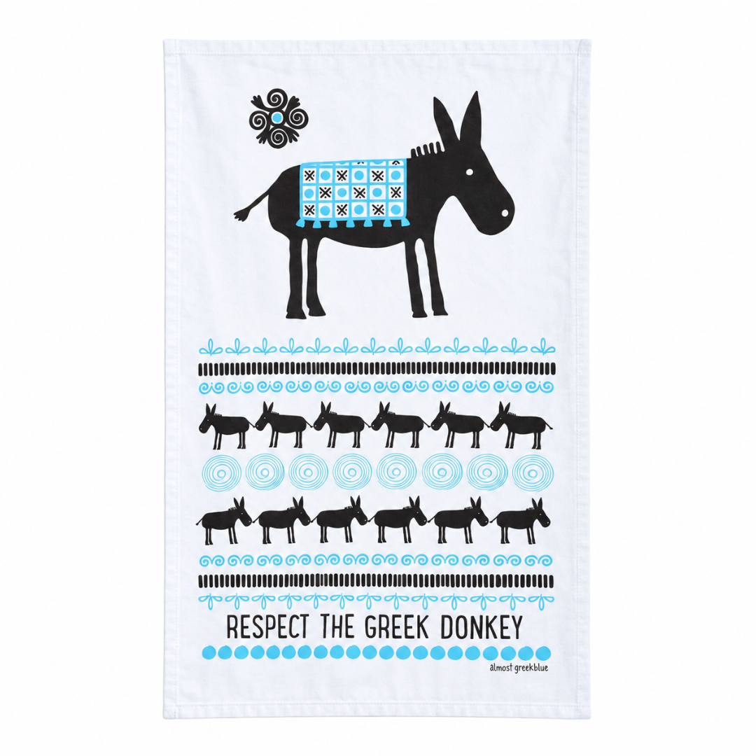 A white kitchen tea towel featuring a black donkey silhouette with a blue and black patterned saddle, surrounded by rows of smaller donkeys, Greek-inspired stripes, and the text 'RESPECT THE GREEK DONKEY' with the brand 'Klefthouses' printed below.