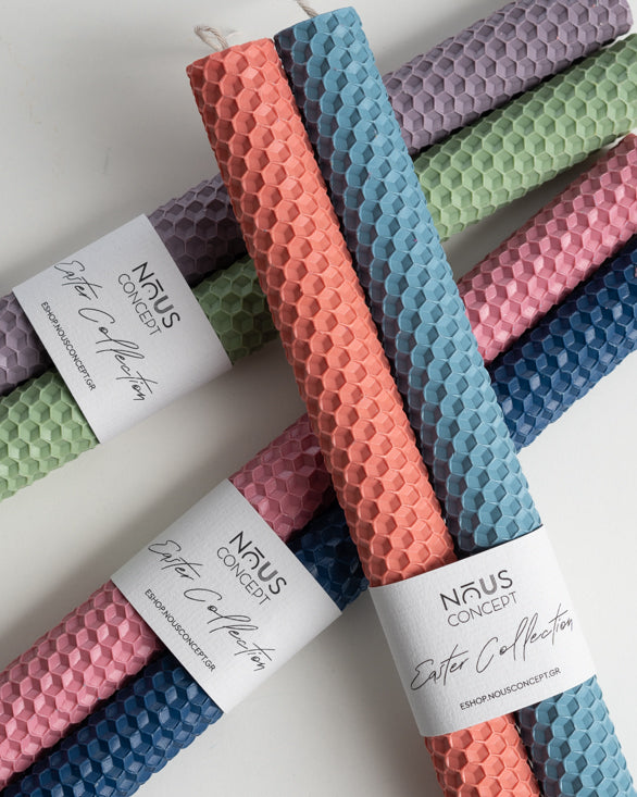 Set of colourful textured candles with 'NAUS CONCEPT' labels on a white background