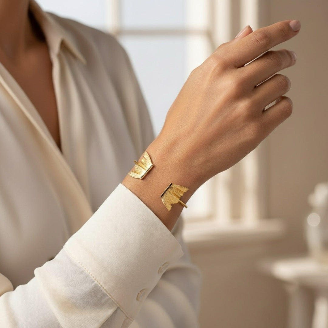 Gold bracelet on a person's wrist with a blurred indoor background