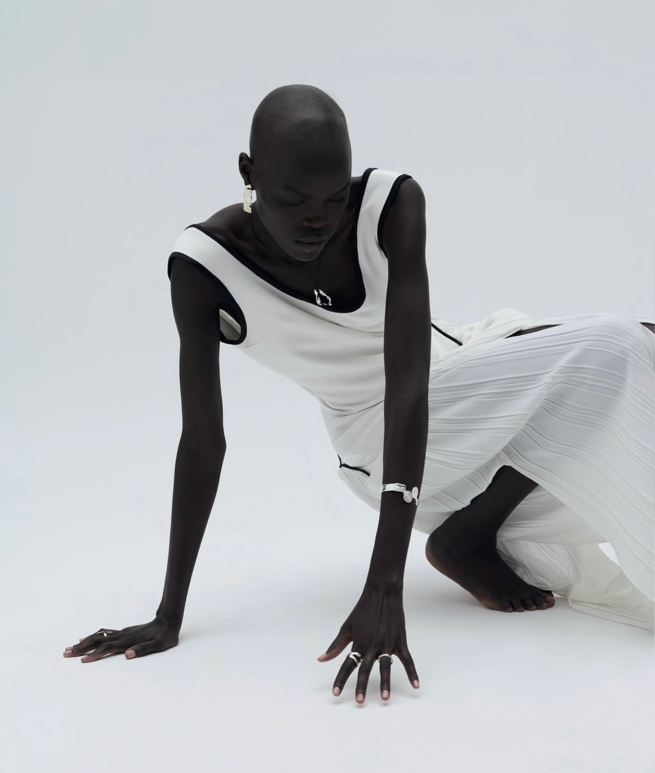 Person wearing a white dress with cut-out design on a white background