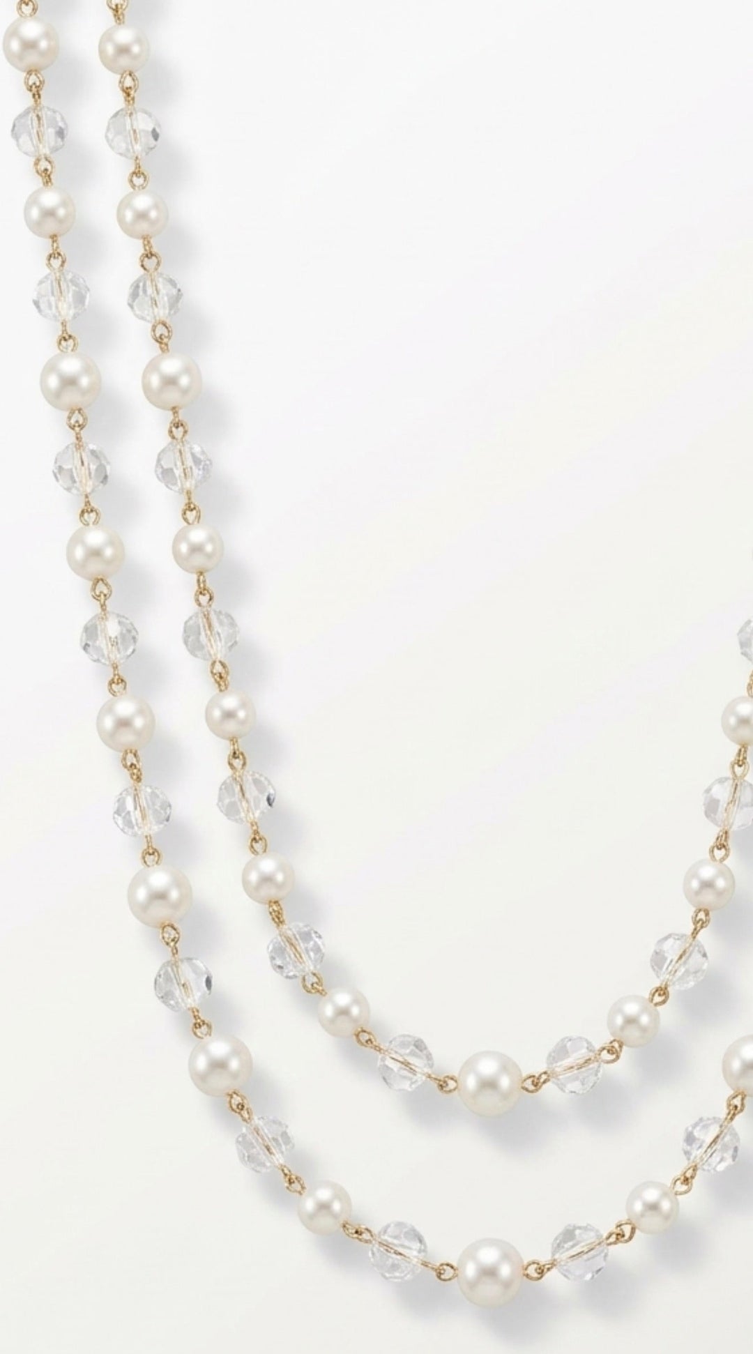 A double-strand pearl and crystal beaded necklace with gold-tone links, draped elegantly on a clean white background.