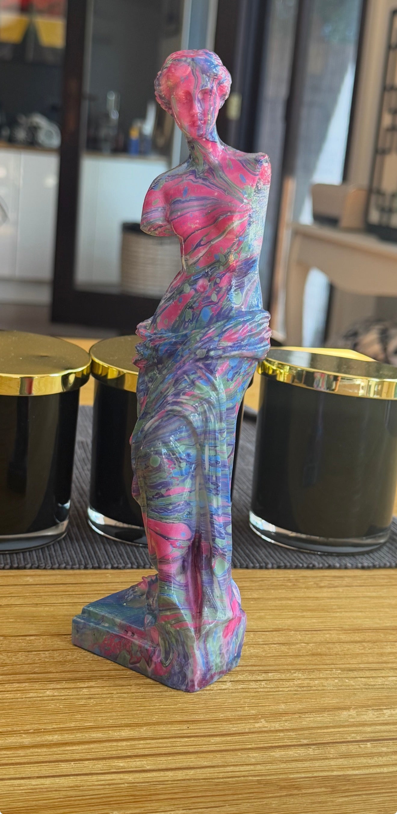 Colorful abstract sculpture on a wooden surface with blurred background