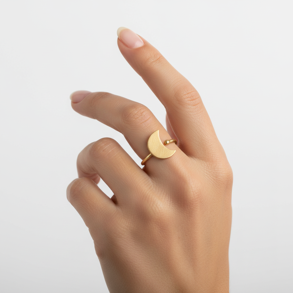 Gold ring on a finger against a plain background