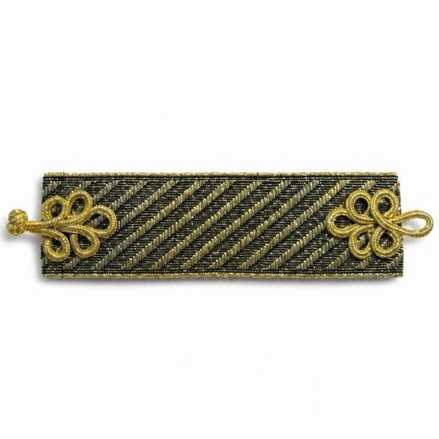A rectangular black and gold striped military-style rank insignia or brooch with ornate gold decorative elements on the left and right ends, shown against a plain white background.