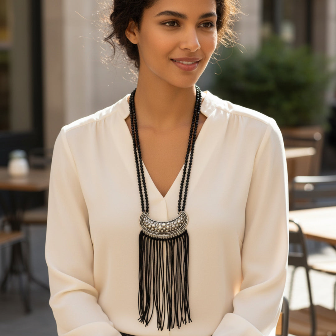 Woman wearing a long black beaded necklace in an outdoor setting