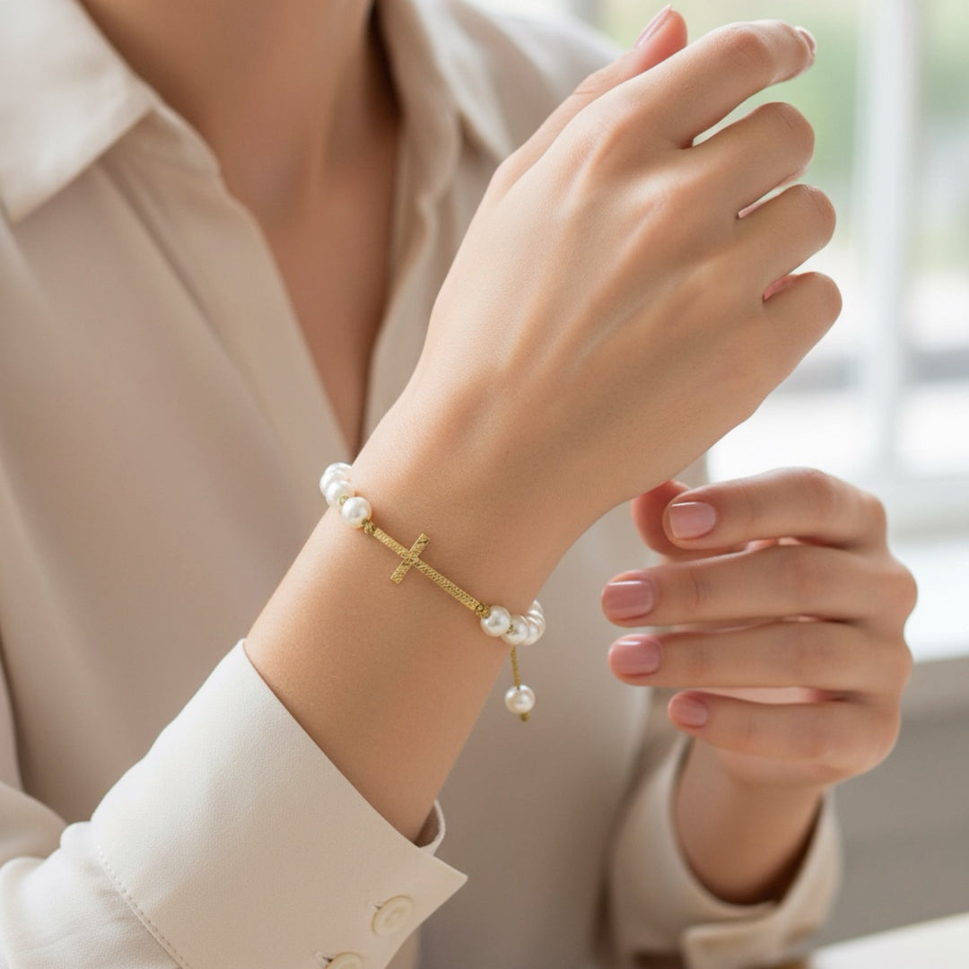 Hand wearing a pearl bracelet with a blurred background